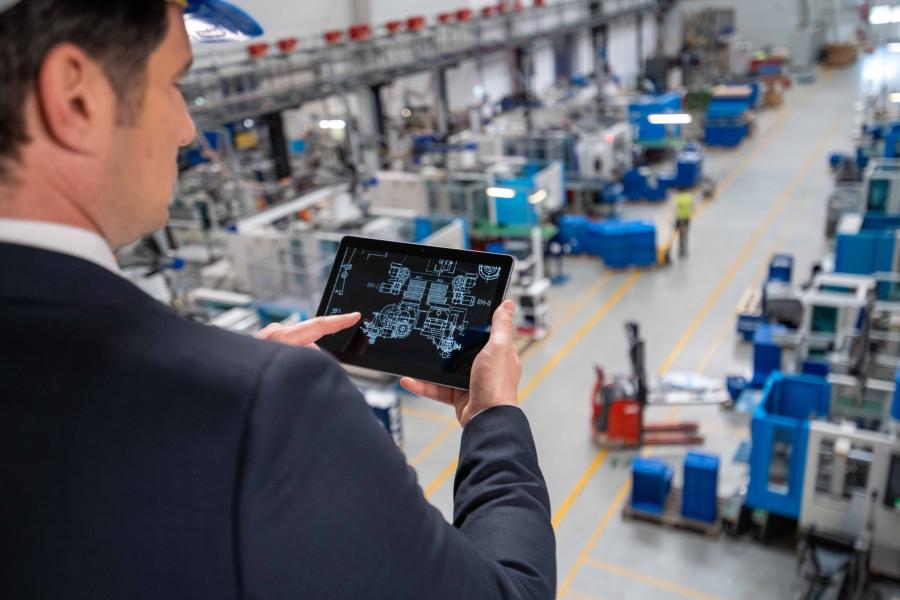 Engineer holding tablet of with digital factory layout